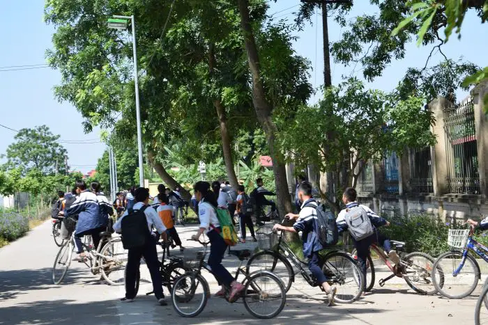 Kids going home from school on their bicycles in a Vietnam village