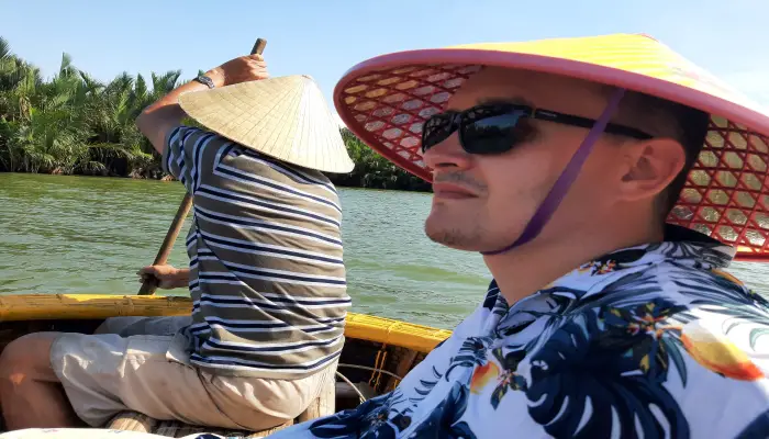 Jake wearing a non la on the basket boats in Hoi-An